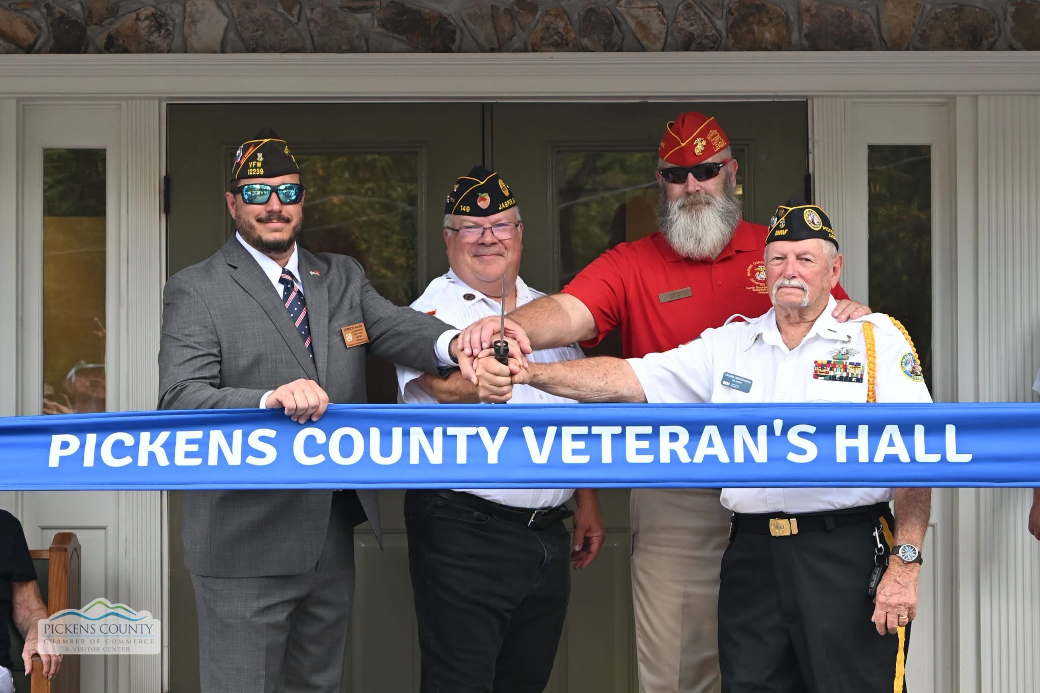 Representatives of local veterans organizations gather at the ribbon for Pickens County Veterans Hall.