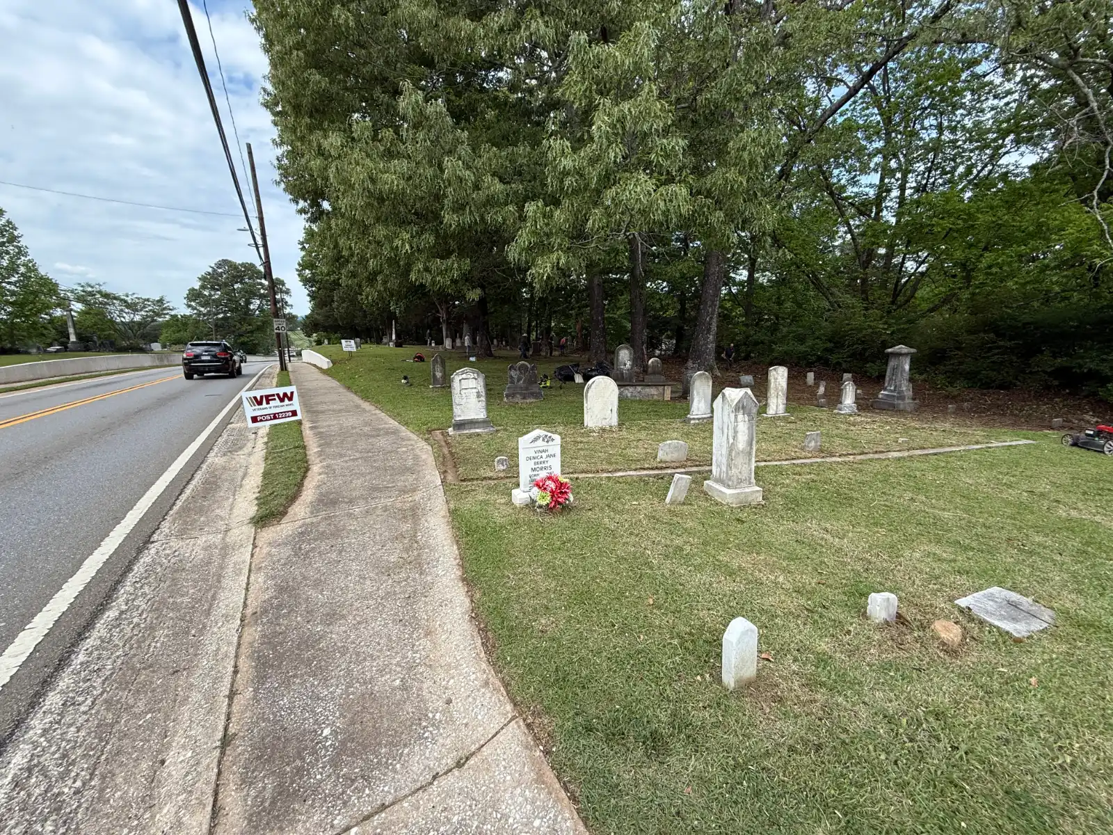 Cleaned cemetery grounds and grave markers beside Church Street, with VFW project signs.